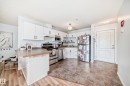 The kitchen features white cabinetry, stainless steel appliances, and a durable countertop - 317 7511 171 Street, Edmonton, AB  - Indoor Photo Showing Kitchen 