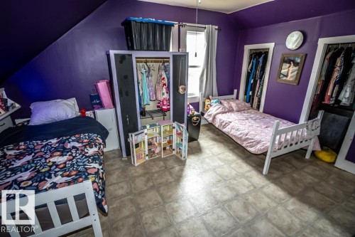 Bedroom featuring tiled flooring and two open closets - 5213 49 Ave, St. Paul Town, AB - Indoor Photo Showing Bedroom