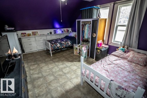 Room featuring sloped ceilings, two windows with white trim, and light-toned tile-look flooring - 5213 49 Ave, St. Paul Town, AB - Indoor Photo Showing Bedroom