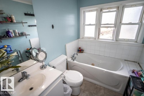 Bathroom featuring a built-in tub, tiled surround, and multi-pane windows - 5213 49 Ave, St. Paul Town, AB - Indoor Photo Showing Bathroom