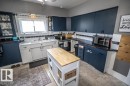 Kitchen featuring dark blue upper cabinetry, white lower cabinetry, and a white tile backsplash with black trim - 5213 49 Ave, St. Paul Town, AB  - Indoor Photo Showing Kitchen 