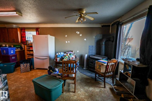 Kitchen area featuring wood-finish cabinetry, a built-in refrigerator, and a ceiling fan - 4114 Main Street, Ashmont, AB - Indoor