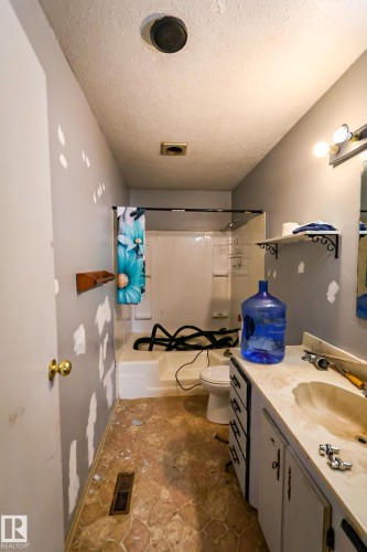 Bathroom featuring a single vanity with storage, a drop-in sink, and an integrated shower-tub combination - 4114 Main Street, Ashmont, AB - Indoor