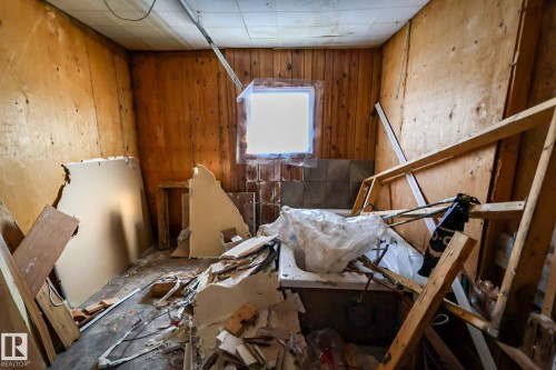 Room with wood paneling, a small window, and a section of wall tiling - 4114 Main Street, Ashmont, AB - Indoor Photo Showing Other Room