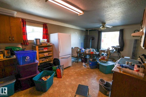 Interior space featuring light-toned flooring, two windows with drapery, and a ceiling fan - 4114 Main Street, Ashmont, AB - Indoor Photo Showing Other Room