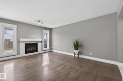 Spacious room featuring a central fireplace with a white tile surround and mantel - 