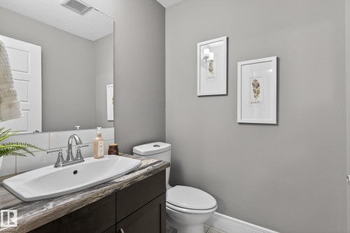 Bathroom featuring a vanity with a rectangular basin, chrome faucet, and a stone-finish countertop - 2017 Westerra Loop, Stony Plain, AB - Indoor Photo Showing Bathroom