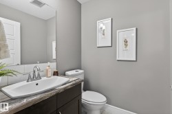 Bathroom featuring a vanity with a rectangular basin, chrome faucet, and a stone-finish countertop - 