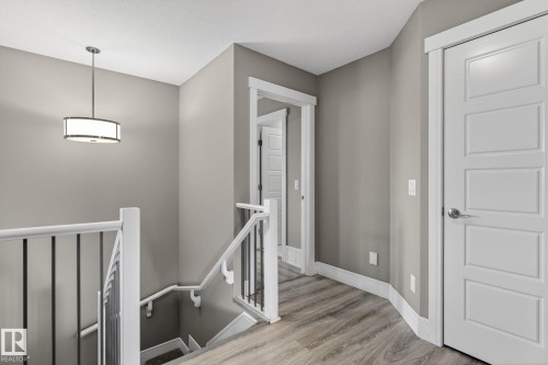 Upper landing featuring wood-finish flooring and a contemporary pendant light fixture - 2017 Westerra Loop, Stony Plain, AB - Indoor Photo Showing Other Room