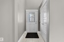 Entryway featuring a white door with decorative glass inserts, white trim, light gray walls, and light-toned tile flooring - 2017 Westerra Loop, Stony Plain, AB  - Indoor Photo Showing Other Room 