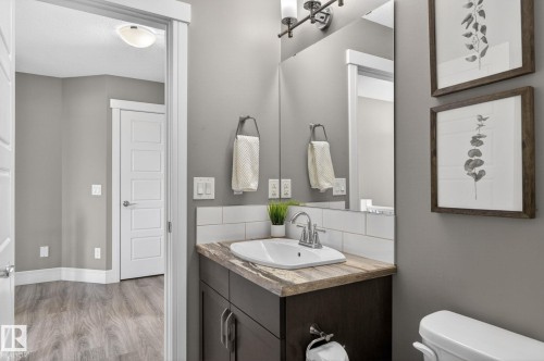Vanity with wood-finish countertop, undermount sink, and chrome faucet - 2017 Westerra Loop, Stony Plain, AB - Indoor Photo Showing Bathroom