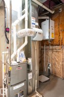 Dedicated utility area featuring a Lennox furnace, a tankless water heater, and a whole-home humidifier - 