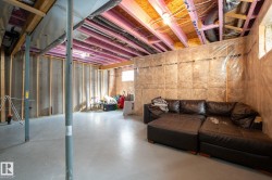 Unfinished basement featuring exposed wood joists, concrete walls, and insulation - 