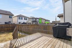 Spacious wood deck with a full wood railing and privacy fencing, offering ample outdoor living space - 