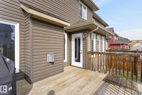 Expansive wood deck featuring a full-light exterior door, multiple windows, brown horizontal siding, and a wood railing - 2017 Westerra Loop, Stony Plain, AB - Outdoor With Deck Patio Veranda With Exterior