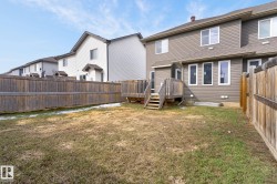 Spacious backyard featuring a wood deck with stairs, surrounded by a wooden privacy fence - 