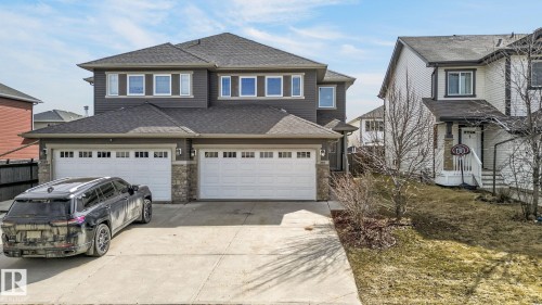 Two-story residence featuring dark siding with stone accents and multiple large windows - 2017 Westerra Loop, Stony Plain, AB - Outdoor With Facade