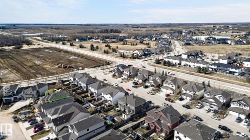 Aerial perspective showcasing a developed residential neighborhood with a mixture of single-family homes and townhomes, featuring paved roads and sidewalks - 2017 Westerra Loop, Stony Plain, AB - Outdoor With View