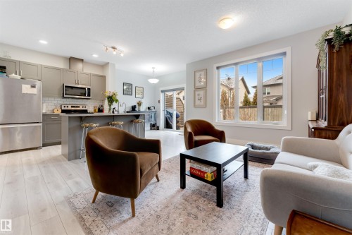 Open-concept living space featuring light wood-finish flooring throughout - 11 4835 Wright Drive, Edmonton, AB - Indoor