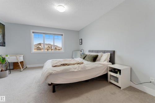 Bedroom featuring light gray walls, white trim, and light-colored carpet flooring - 11 4835 Wright Drive, Edmonton, AB - Indoor Photo Showing Bedroom