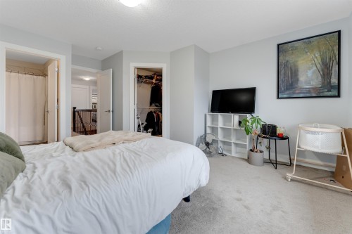 Carpeted bedroom with a built-in closet featuring wire shelving - 11 4835 Wright Drive, Edmonton, AB - Indoor Photo Showing Bedroom