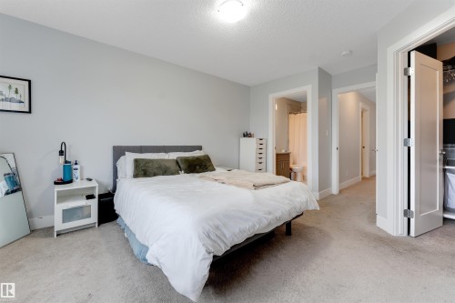 Carpeted bedroom with light gray wall paint and white trim - 11 4835 Wright Drive, Edmonton, AB - Indoor Photo Showing Bedroom