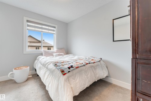 Bedroom featuring light gray wall paint, carpeting, a white-framed window with blinds, and white baseboards - 11 4835 Wright Drive, Edmonton, AB - Indoor Photo Showing Bedroom