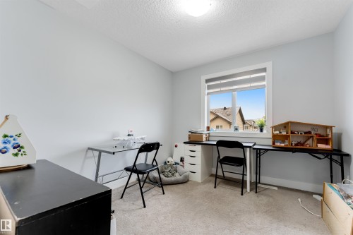 Room featuring a large window with white trim, light gray walls, and textured carpeting - 11 4835 Wright Drive, Edmonton, AB - Indoor Photo Showing Office