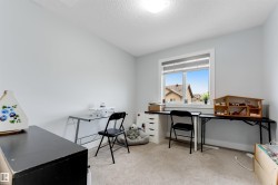 Room featuring a large window with white trim, light gray walls, and textured carpeting - 