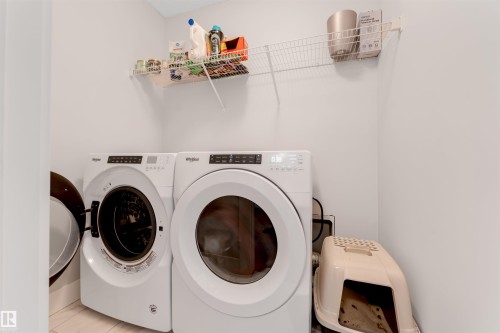 Dedicated laundry area featuring a front-loading washer and dryer set - 11 4835 Wright Drive, Edmonton, AB - Indoor Photo Showing Laundry Room