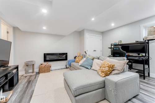Finished lower level featuring recessed lighting and wood-finish flooring - 11 4835 Wright Drive, Edmonton, AB - Indoor With Fireplace