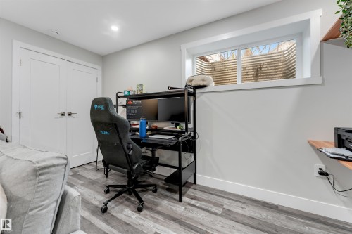 Room featuring light gray walls, wood-finish flooring, and a window with a well enclosure - 11 4835 Wright Drive, Edmonton, AB - Indoor Photo Showing Office