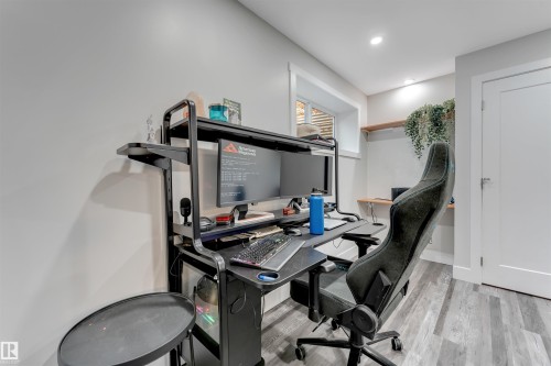 Versatile room featuring wood-finish flooring, recessed lighting, and a window with white trim - 11 4835 Wright Drive, Edmonton, AB - Indoor