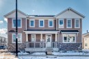 The property features a two-story exterior with light brown siding and stone accents - 840 Stillwater Boulevard, Edmonton, AB  - Outdoor With Facade 