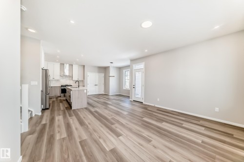 The property features an open-concept living space with light wood-style flooring throughout - 840 Stillwater Boulevard, Edmonton, AB - Indoor