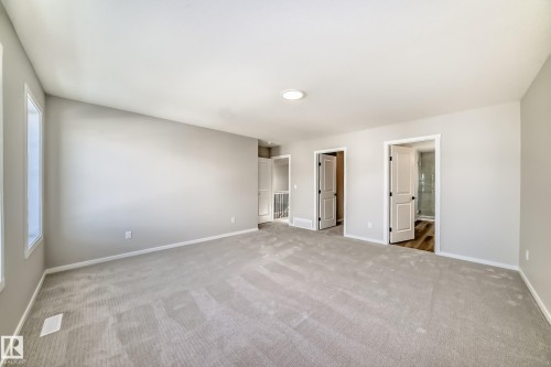 Spacious room featuring light gray carpeting, neutral wall colors, and ample natural light from windows - 840 Stillwater Boulevard, Edmonton, AB - Indoor Photo Showing Other Room