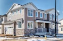 The property features a two-story design with light-colored siding and stone accents on the lower level - 840 Stillwater Boulevard, Edmonton, AB  - Outdoor With Facade 