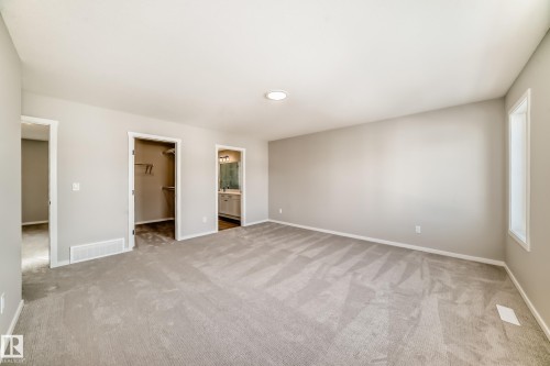 Spacious room featuring light gray carpeting, neutral wall colors, and a ceiling light fixture - 840 Stillwater Boulevard, Edmonton, AB - Indoor Photo Showing Other Room