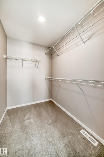 Spacious closet featuring wall-mounted wire shelving, light grey carpeting, and a recessed ceiling light - 840 Stillwater Boulevard, Edmonton, AB - Indoor With Storage