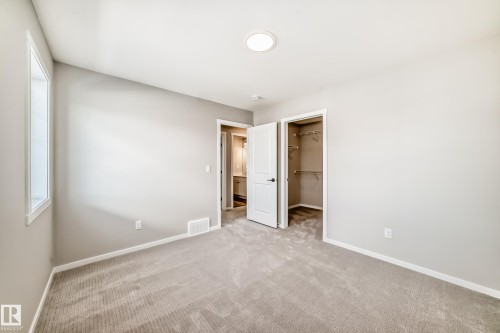 This room features light gray walls, a window with white trim, and a ceiling light fixture - 840 Stillwater Boulevard, Edmonton, AB - Indoor Photo Showing Other Room