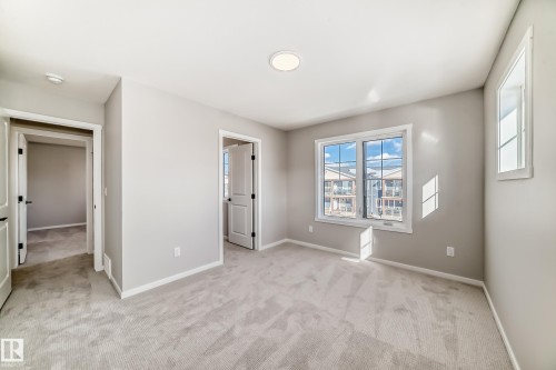 This room features neutral-toned walls, light-colored carpet flooring, and a window providing natural light - 840 Stillwater Boulevard, Edmonton, AB - Indoor Photo Showing Other Room