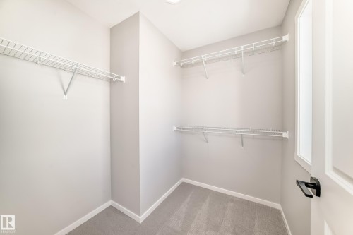 Closet featuring white wire shelving, light grey walls, and grey carpeting - 840 Stillwater Boulevard, Edmonton, AB - Indoor With Storage