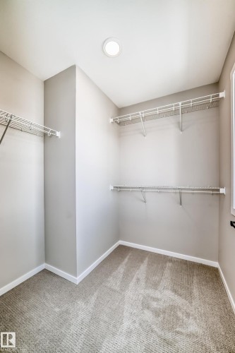 Walk-in closet featuring carpeted flooring, ample shelving, and recessed lighting - 840 Stillwater Boulevard, Edmonton, AB - Indoor With Storage