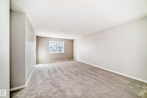 Spacious room featuring light-colored walls, recessed ceiling lighting, and a window providing natural light - 840 Stillwater Boulevard, Edmonton, AB - Indoor Photo Showing Other Room
