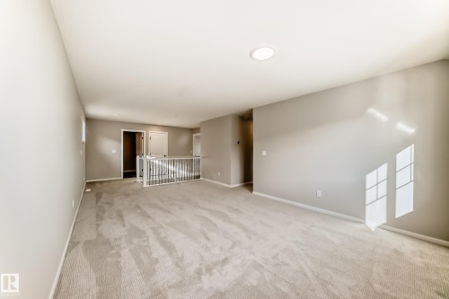 Spacious room with light-colored carpeting, neutral painted walls, and an overhead circular light fixture - 840 Stillwater Boulevard, Edmonton, AB - Indoor Photo Showing Other Room