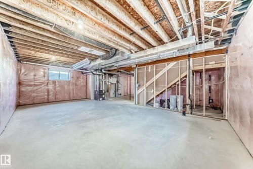 Expansive unfinished basement featuring concrete flooring, exposed wooden ceiling joists, and a window for natural light - 840 Stillwater Boulevard, Edmonton, AB - Indoor Photo Showing Basement