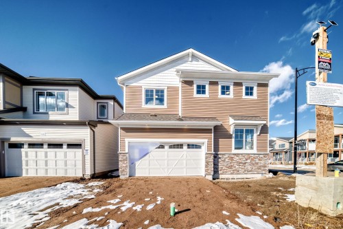 The property features a two-story exterior with light brown siding, white trim, and a partial stone facade - 840 Stillwater Boulevard, Edmonton, AB - Outdoor With Facade