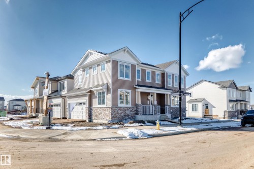 The property features a two-story design with light-colored siding and a stone facade - 840 Stillwater Boulevard, Edmonton, AB - Outdoor With Facade