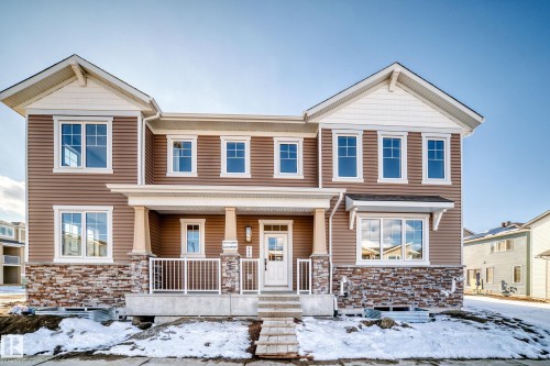The property features an exterior of brown siding with stone accents on the lower level - 840 Stillwater Boulevard, Edmonton, AB - Outdoor With Deck Patio Veranda With Facade