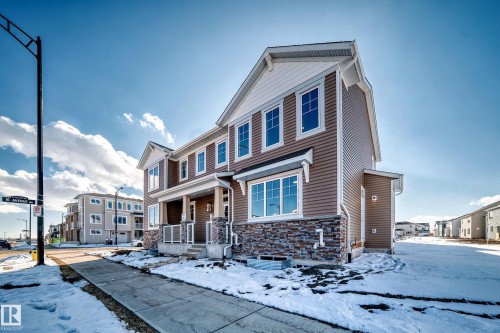 The property features a brown exterior with white trim and a stone facade - 840 Stillwater Boulevard, Edmonton, AB - Outdoor With Facade